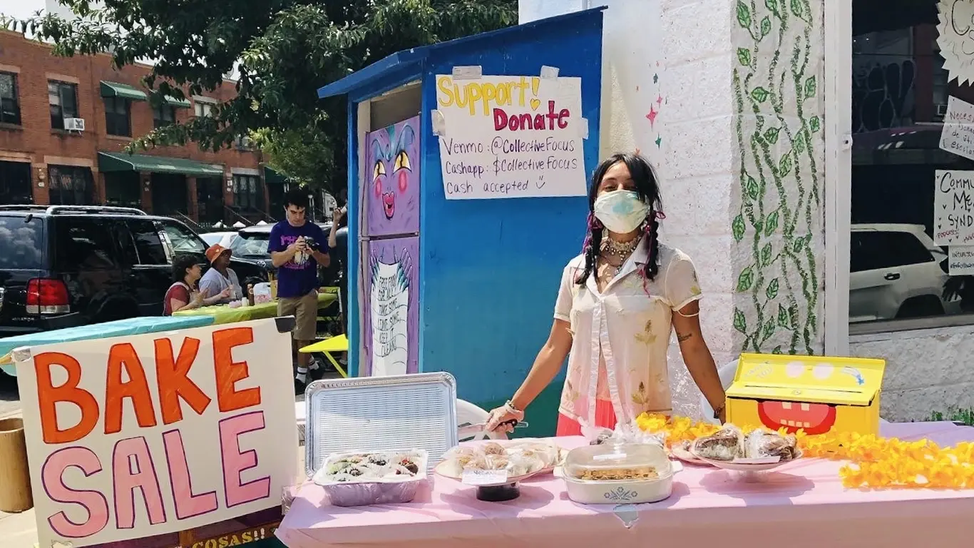Volunteer hosting a bake sale to raise money for a community fridge